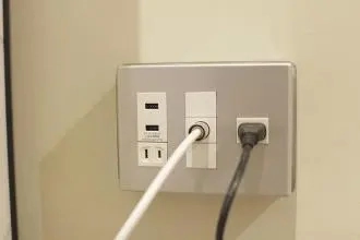 power cord with plug at the end, plugged into a China outlet with ground post for TV